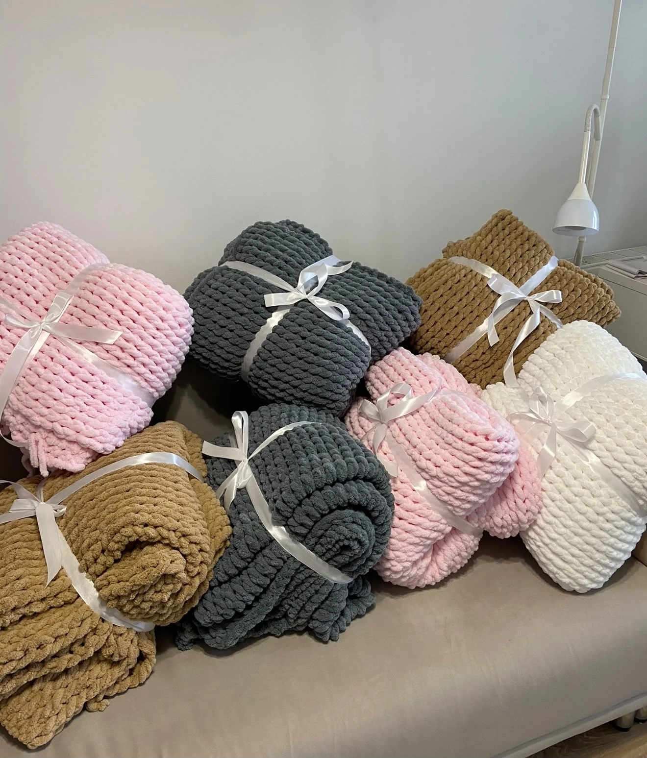 Pink, charcoal, camel and white handmade blankets wrapped with white ribbons