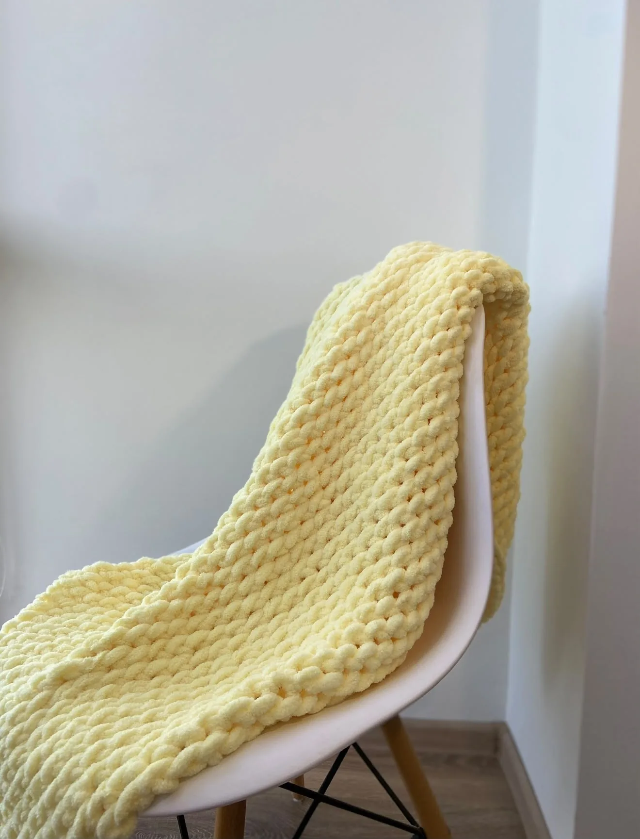 Golden yellow knitted blanket draped on a chair