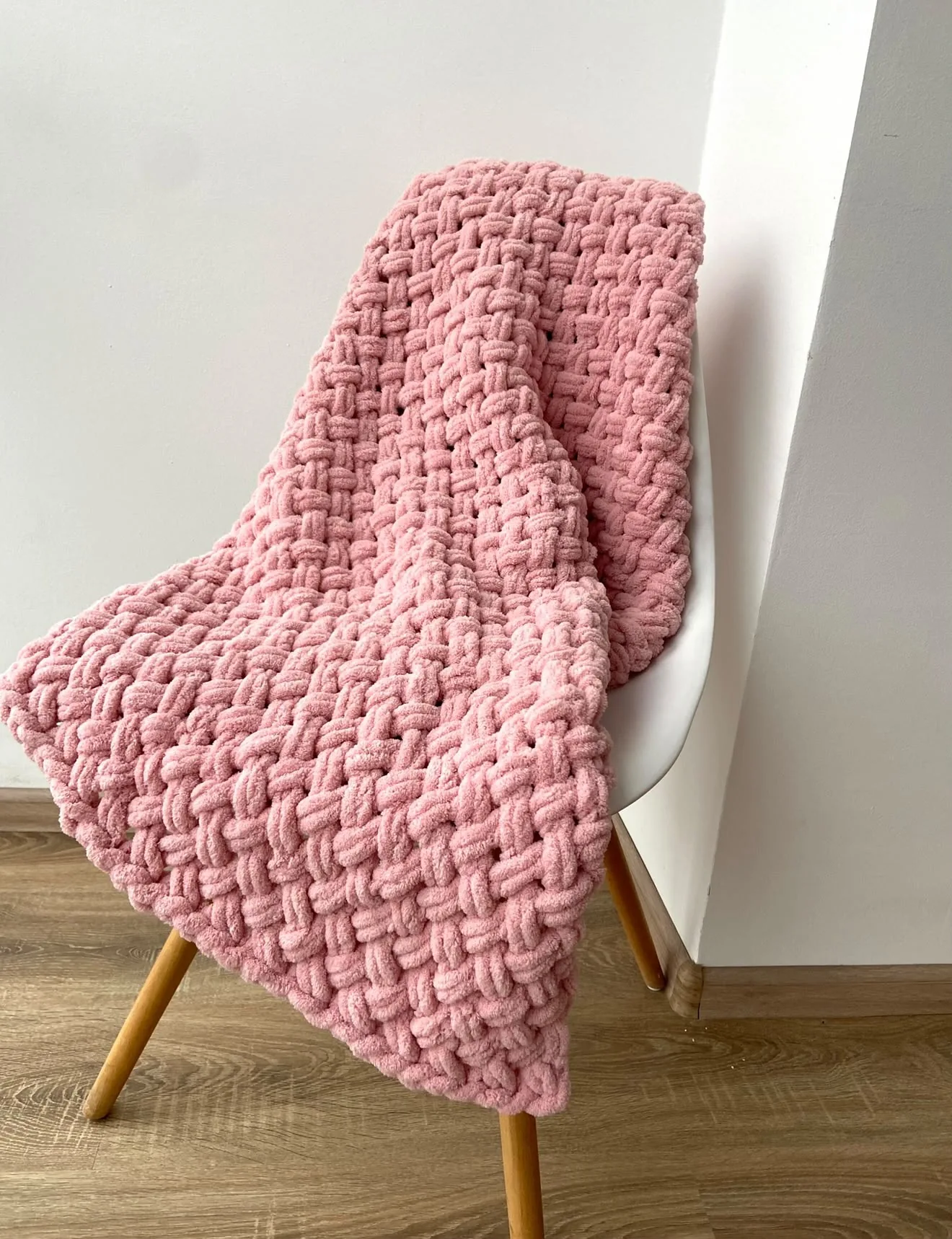Rose pink knitted blanket over a chair