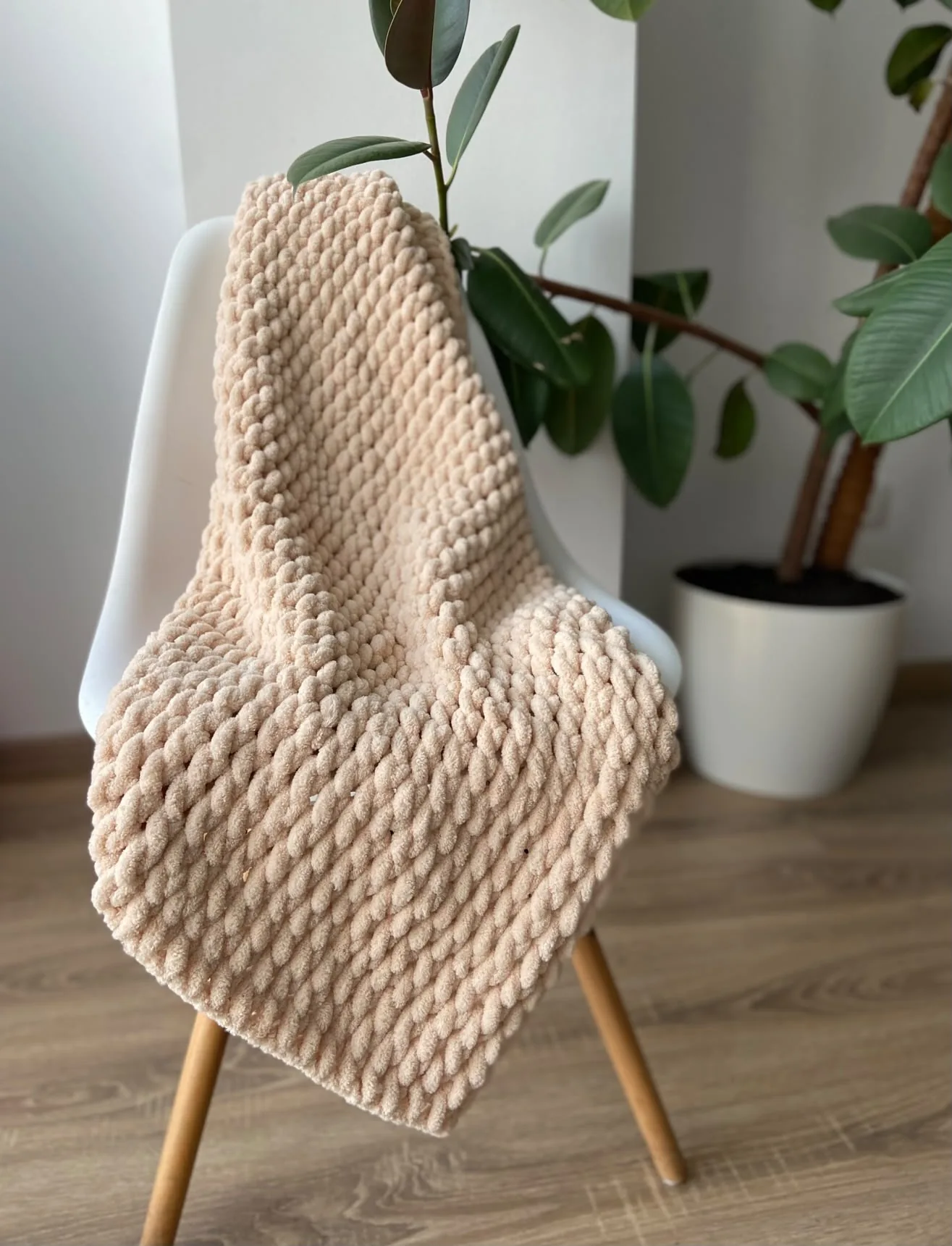 Sand coloured knitted blanket on a chair