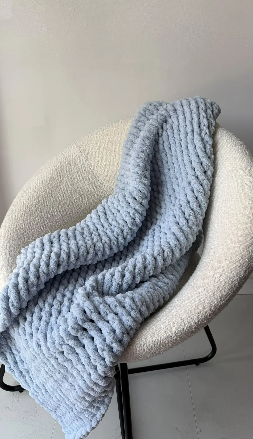Sky blue knitted blanket draped over a chair