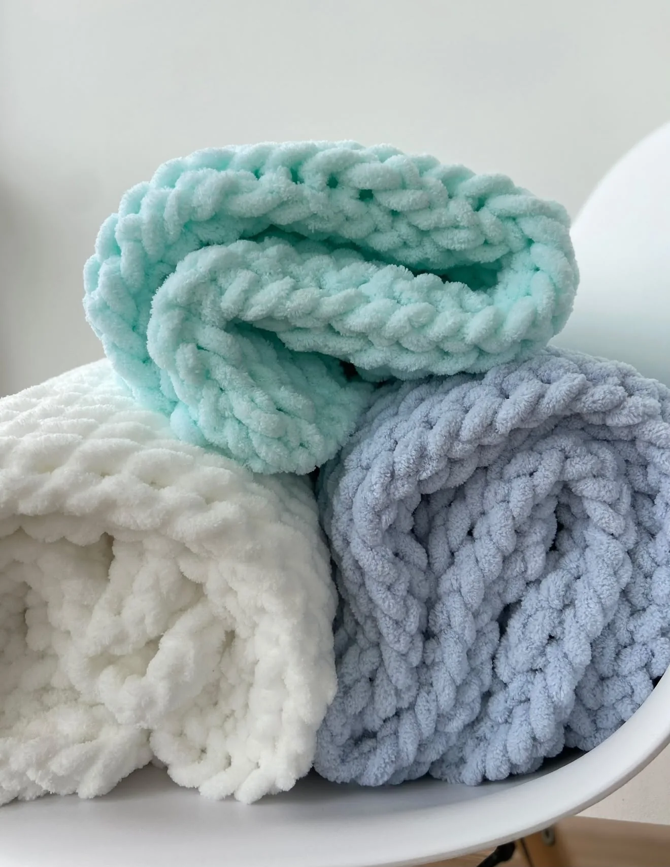 Rolled blankets in mint, cream and pale blue