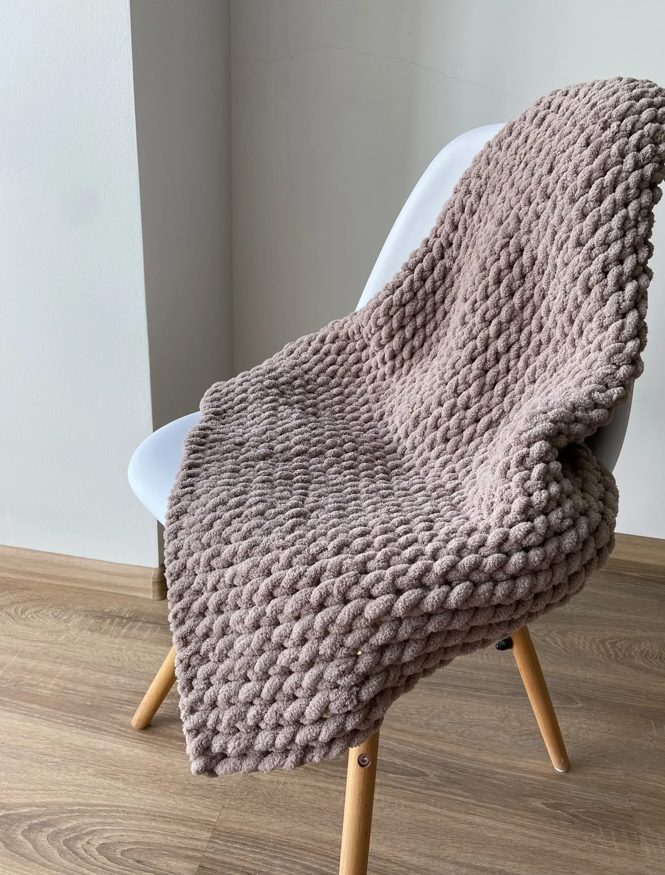 Taupe knitted blanket draped on a chair
