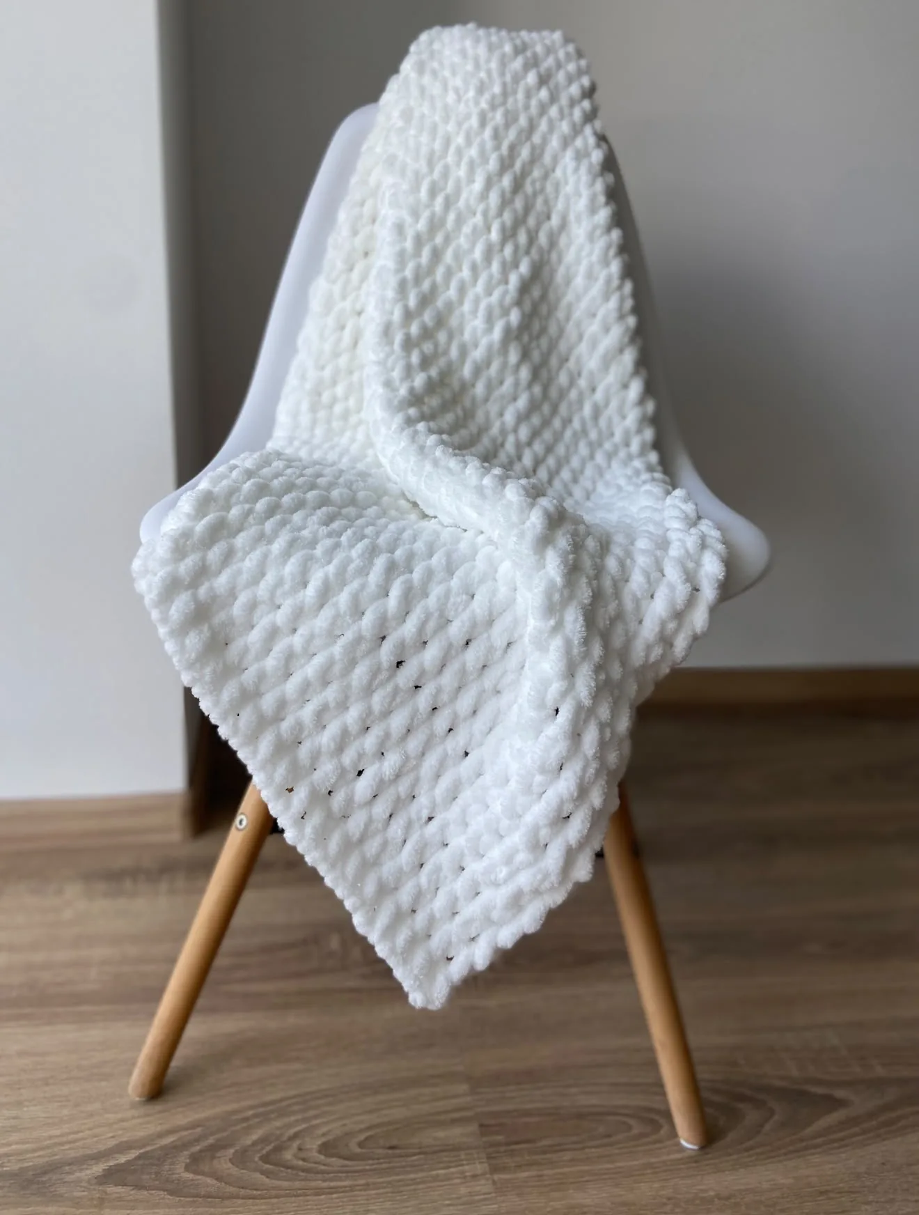 White knitted blanket draped over a chair